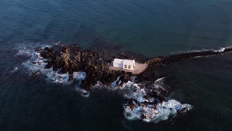capilla blanca en una isla rocosa en creta, vista aérea