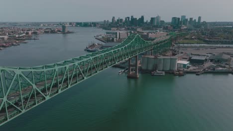 Drohne-über-Dem-Fluss-Zur-Tobin-Bridge-Mit-Der-Innenstadt-Von-Boston-MA-Im-Hintergrund