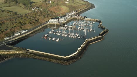 Un-Tranquilo-Puerto-Deportivo-Con-Barcos-Atracados-En-El-Lago-Carlingford,-Condado-De-Louth,-Irlanda,-En-Un-Día-Soleado,-Vista-Aérea