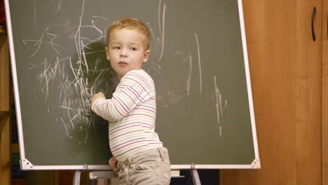 Kreativer-Kleiner-Junge,-Der-Auf-Einer-Tafel-Zeichnet