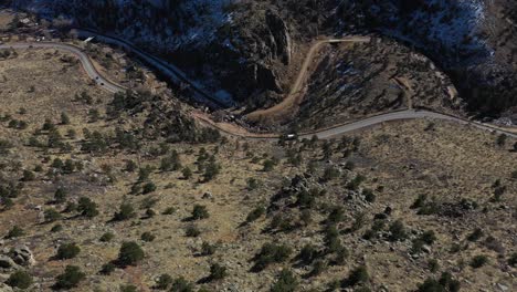 Los-Autos-De-La-Carretera-De-La-Cresta-De-La-Montaña-Se-Desplazan-Hacia-Abajo.-Disparo-De-Revelación-Aérea-4k