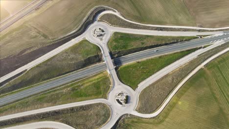 vista aérea de drones sobre una intersección de cruce de carreteras de campo. tráfico en el paso aéreo en un paisaje rural. imágenes de alta calidad 4k