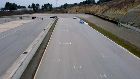 aerial drone shot of sports cars on a circuit