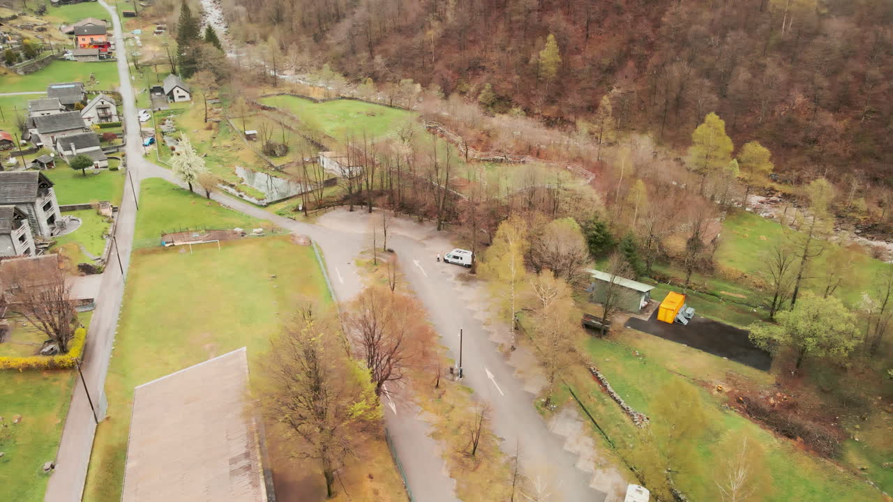 деревья осеннего леса зимой, белый фургон припаркован на фоне природного пейзажа в кантоне тичино, швейцария