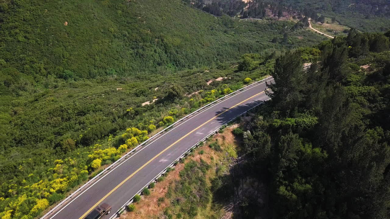 conducción de automóviles en la carretera vacía de la ladera de la montaña