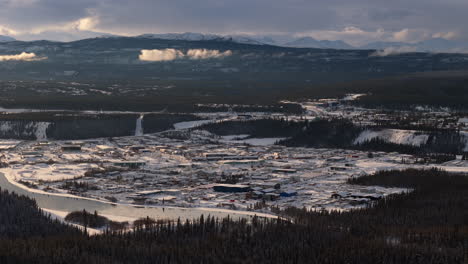 stunning aerial view of whitehorse, yukon, at sunset. snow-covered landscapes and the yukon river glisten in golden hour light.
