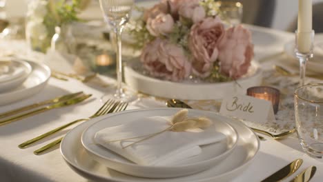 close up of table set for meal at wedding reception with place card for bride 1