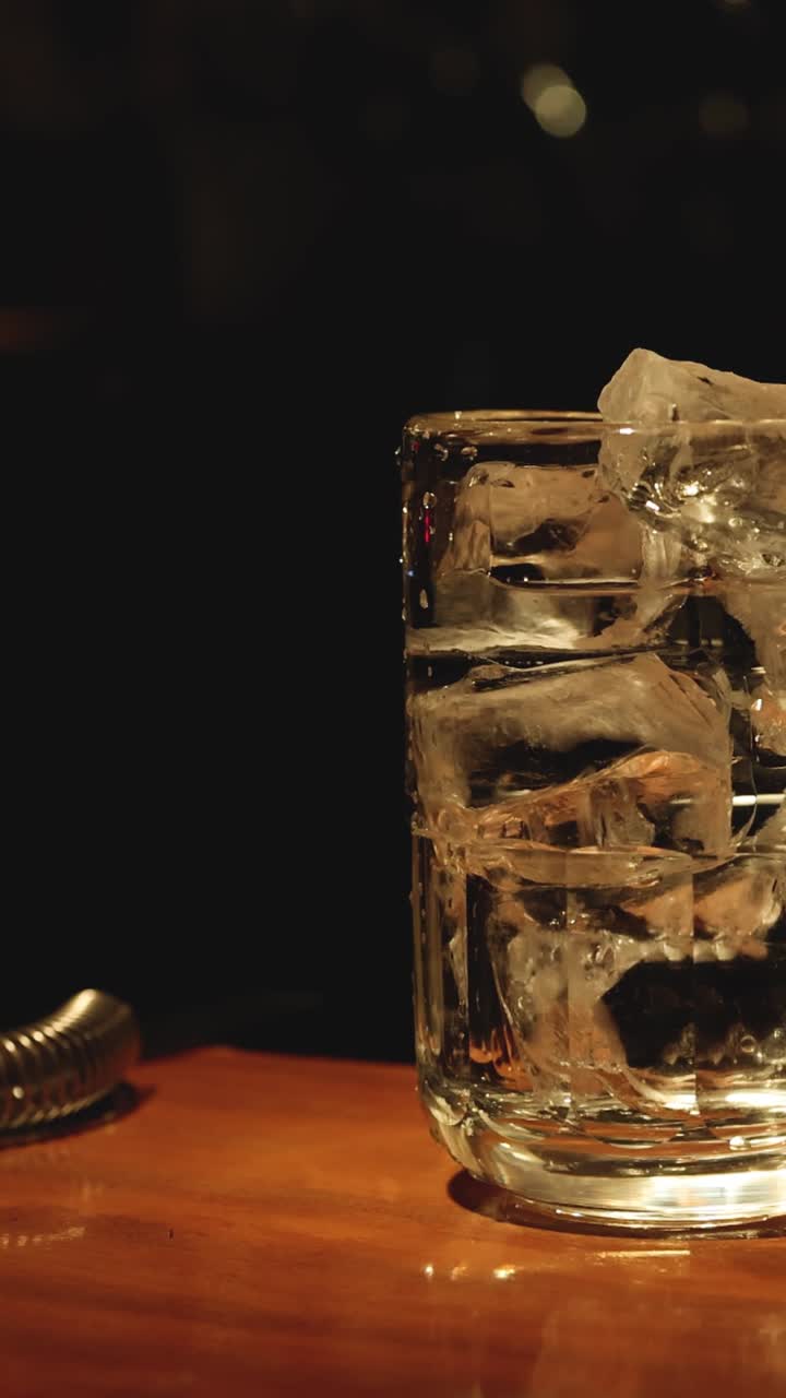 el hielo se derrite en un vaso de whisky con el tiempo.