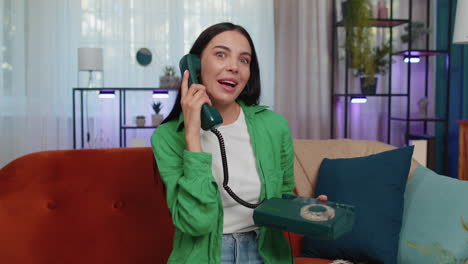 Mujer-Joven-En-El-Sofá-De-Casa-Hablando-Por-Teléfono-Retro-Con-Cable-De-Los-Años-80,-Engañando,-Haciendo-Muecas