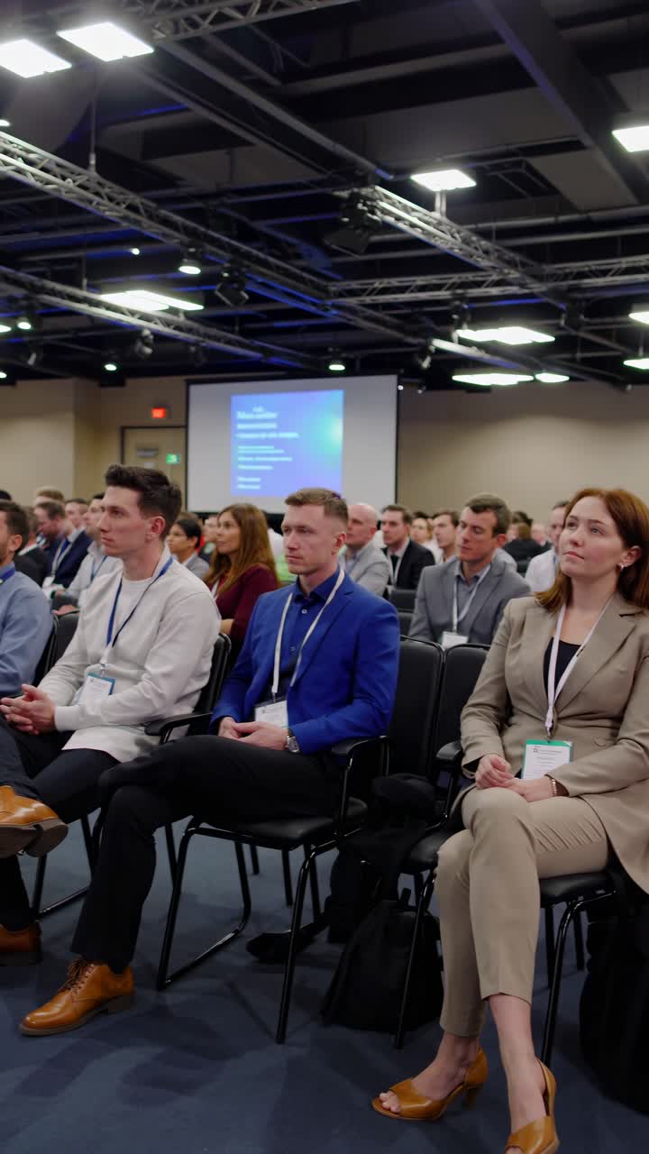 Un fermo immagine video dinamico di una conferenza aziendale ripreso dal basso, che cattura i partecipanti coinvolti