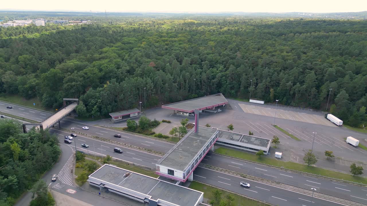 highway rest stop with cars driving on a multi lane highway. Amazing aerial view flight drone shot footage from above