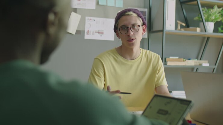 Gen Z Team Leader Talking to Colleague during Office Meeting