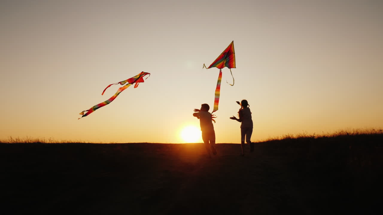 los niños juegan con cometas en un lugar pintoresco al atardecer