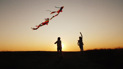 Kinder-Spielen-Mit-Drachen-An-Einem-Malerischen-Ort-Bei-Sonnenuntergang