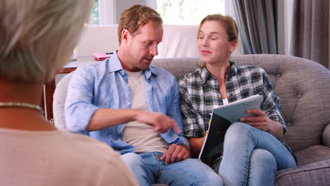 una pareja feliz tomando consejos financieros firma un acuerdo