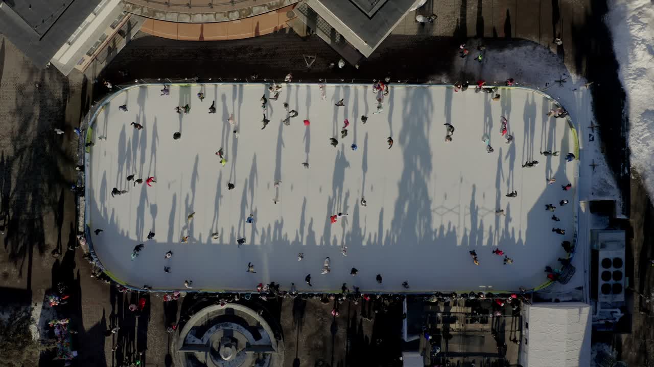 도시 에서 겨울 에 야외 스케이팅 리크 에서 스케이트 를 타고 있는 사람 들 의 공중 드론 시상