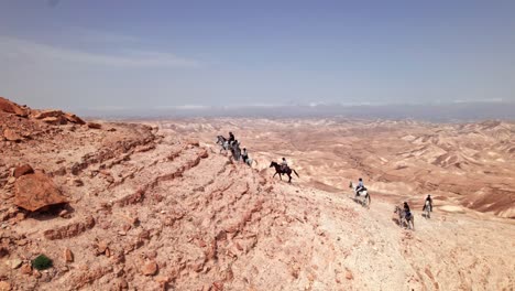 Horses-climbing-a-steep-rocky-mountain-in-the-desert