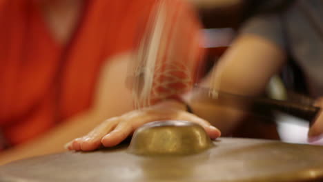 south east asian gamelan bonang traditional instrument being tapped rhythmically with mallet, filmed as close up