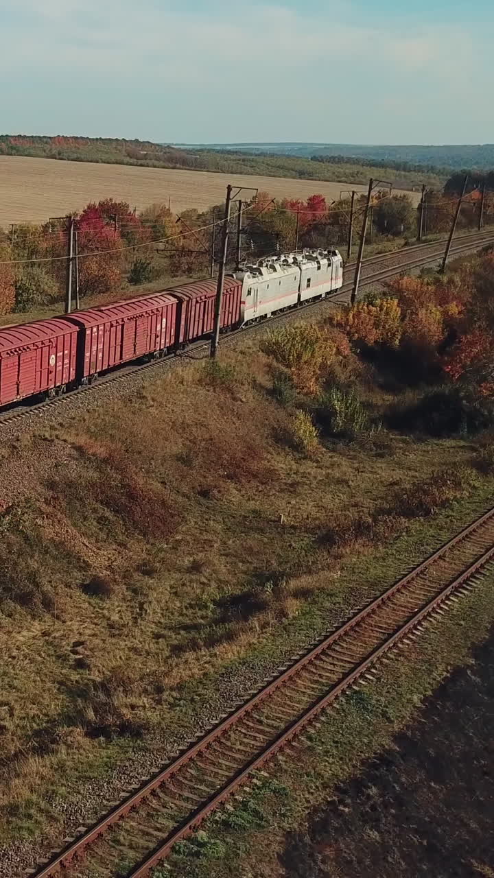 freight train with building materials is passing by rail to the destination. Aerial view Vertical video