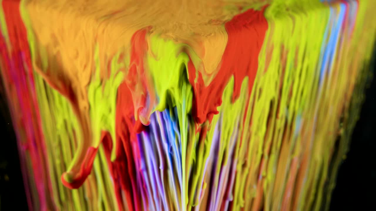 pintura de tinta multicolor fluye lentamente desde el cubo bajo el agua