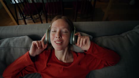 woman listening to music on a couch