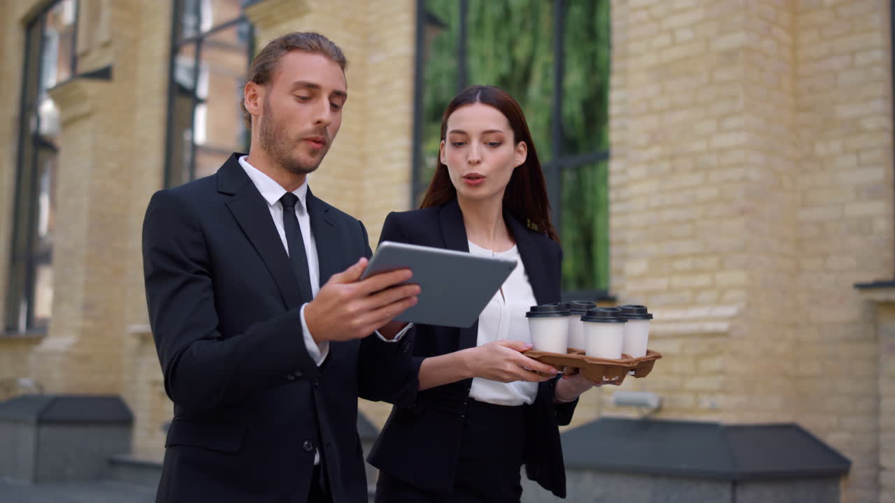 коллеги обсуждают во время ходьбы. люди ходят с планшетом и кофе