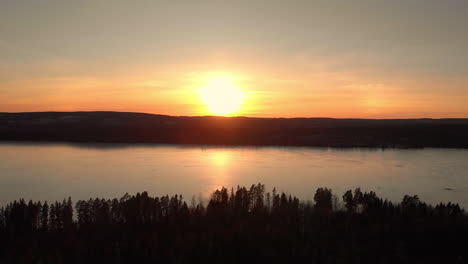 puesta de sol aérea: el dron se desliza sobre paisajes brillantes, capturando cielos vibrantes con tonos cálidos y sombras largas, mientras el sol se sumerge debajo del horizonte, haciendo la transición del día al tranquilo crepúsculo