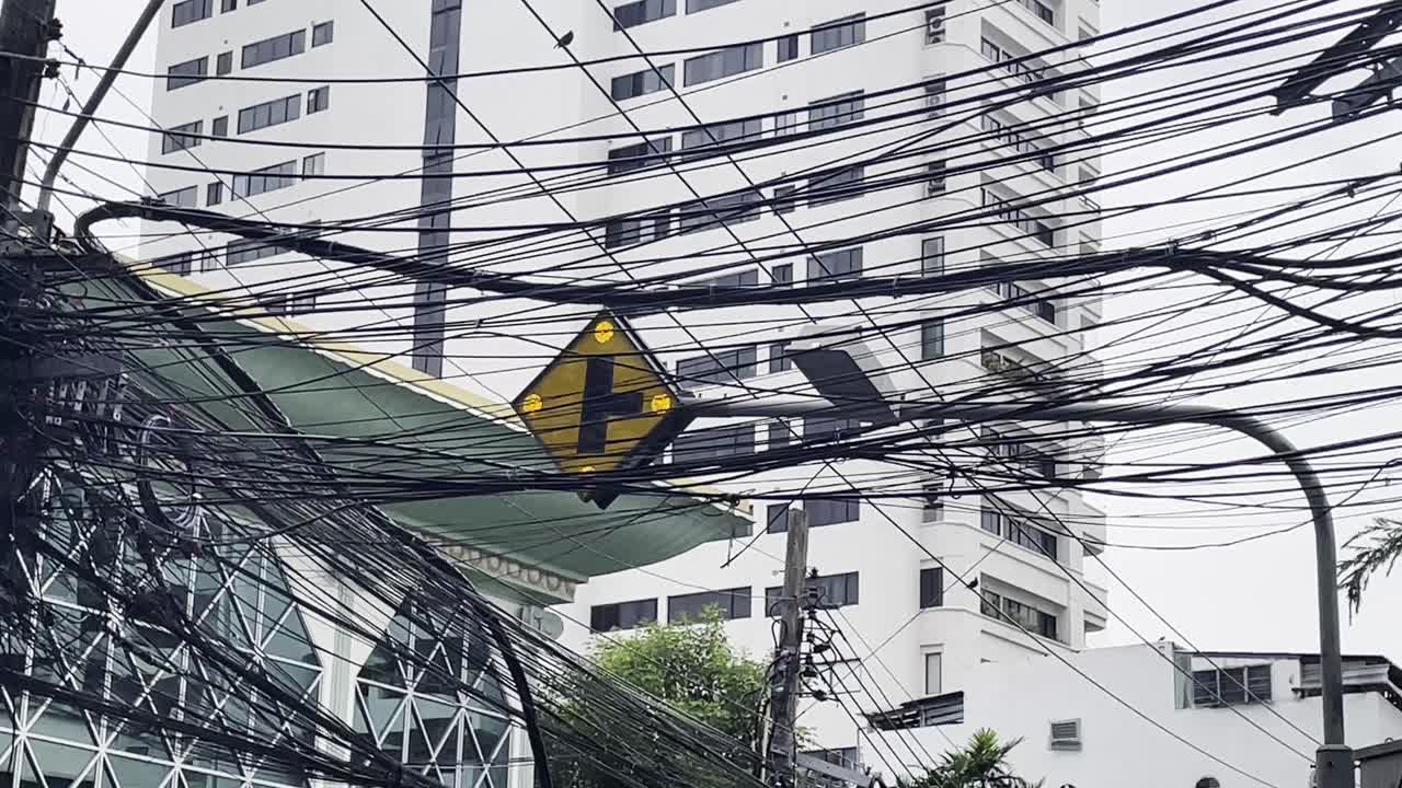 semáforos y cables eléctricos, paisaje urbano cableado de una ciudad del sudeste asiático