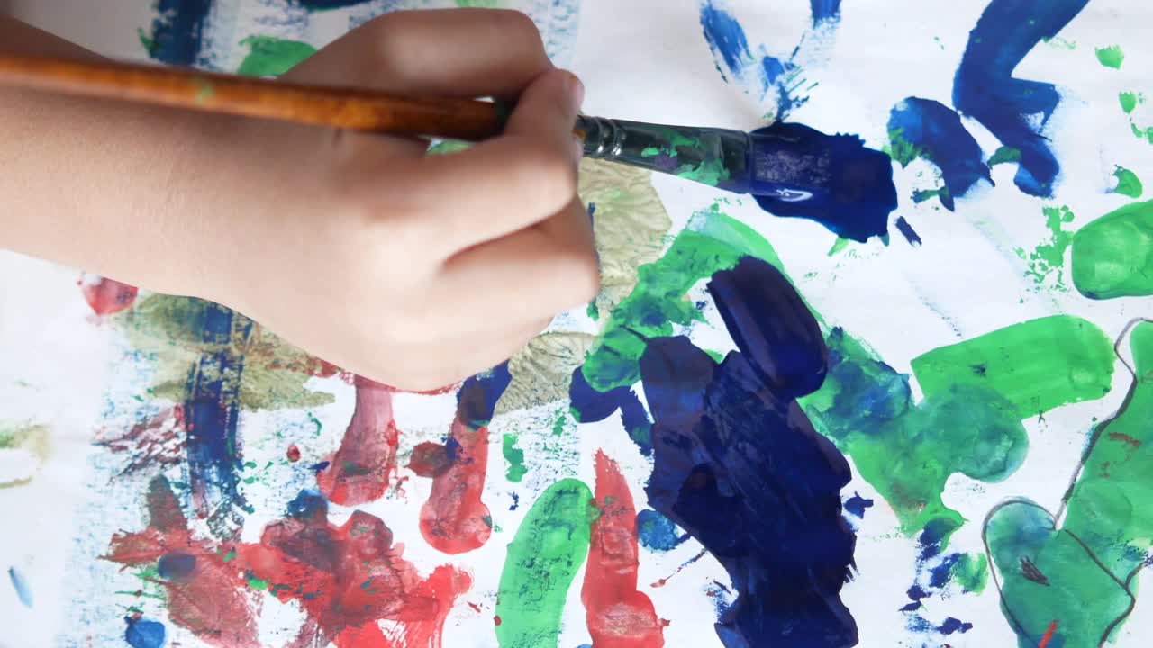 Child painting with colorful paints