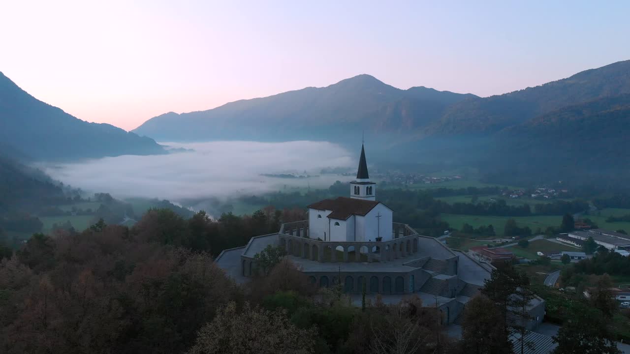 drone approaching Italian Charnel House in Kobarid, early spring morning, dark and misty