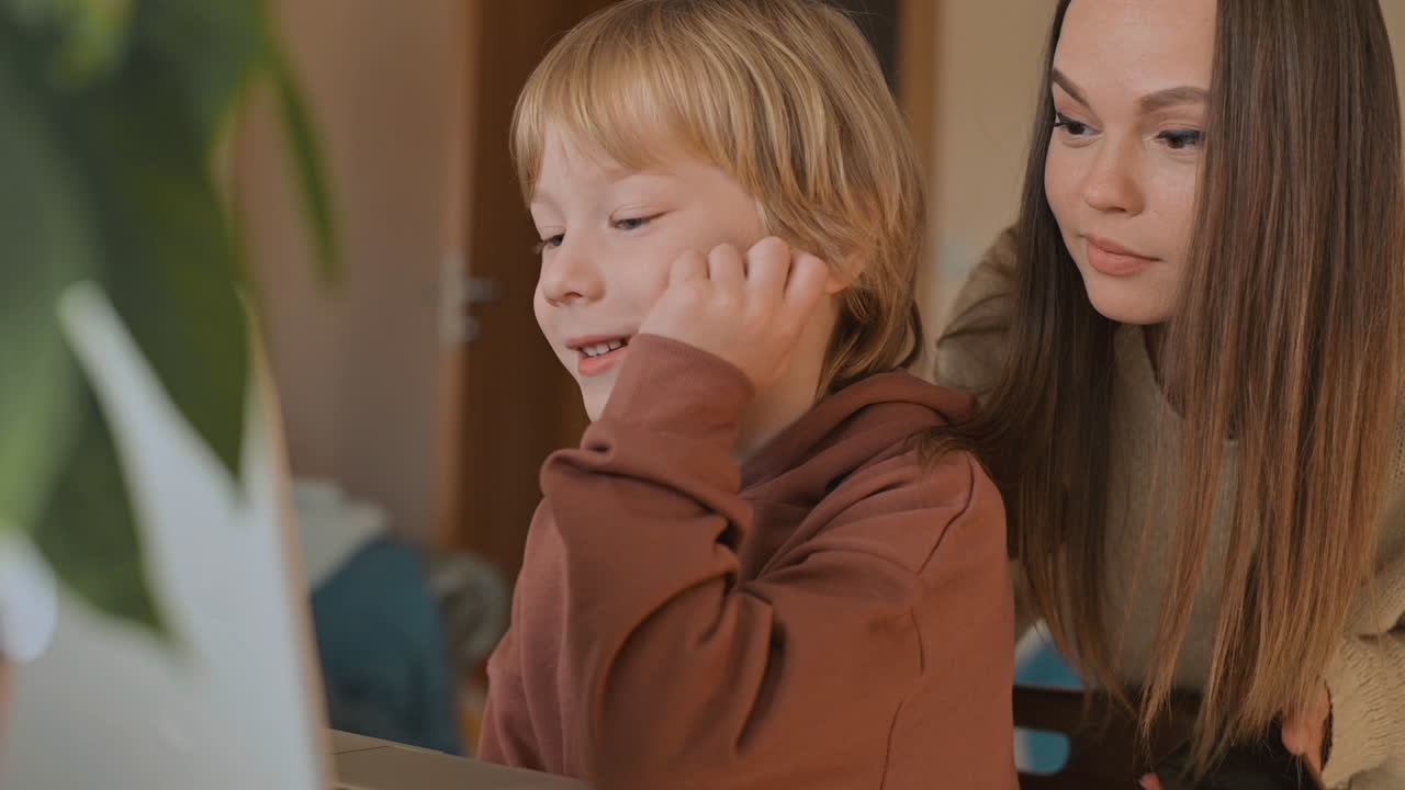 노트북으로 영화를 보고 집에서 즐거운 시간을 보내는 어린 소년과 누나