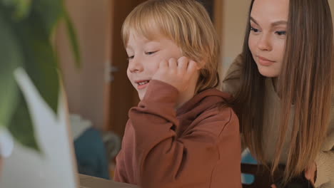 niño pequeño y hermana mayor viendo una película con una laptop y divirtiéndose en casa