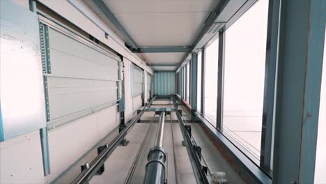 elevator lift cabin moves up inside illuminated elevator shaft with hydraulics with many floors slow motion