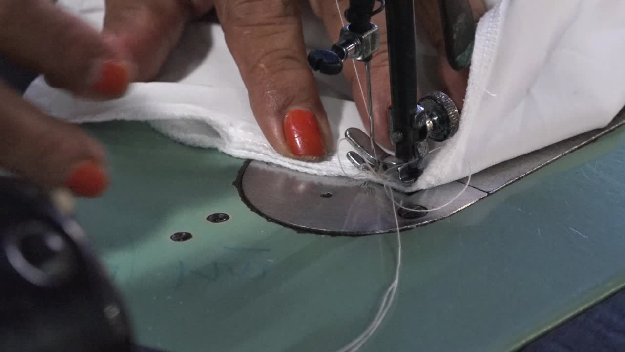 material blanco siendo cosido en una máquina de coser