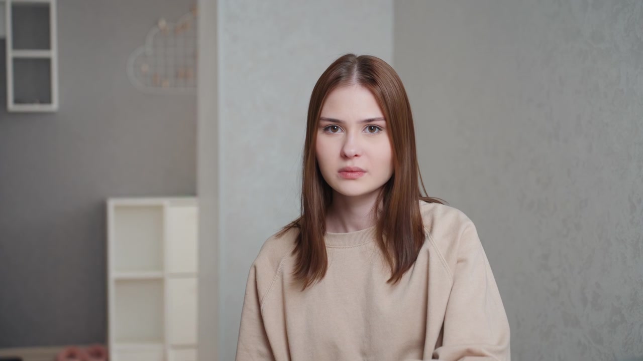 Белый студент закрывает ноутбук за столом, решительное выражение лица, сцена домашнего репетиторства, пожилой репетитор смотрит с беспокойством, комнатное растение на столе, стопка тетрадей, напряженная тишина, нейтральный фон стены, крупный план.