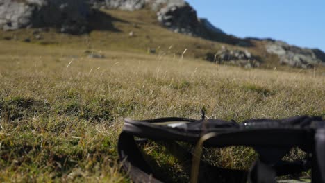 Unrecognizable-drone-taking-off-in-high-mountain-landscape,-yellow-grass,-closeup