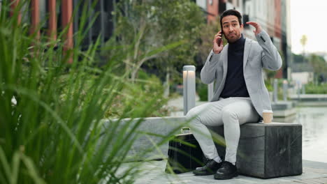 businessman talking on the phone while sitting in a city park