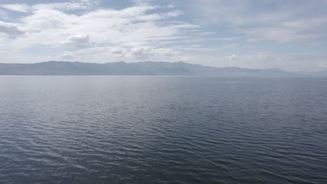 Video-with-a-drone-over-Lake-Skadar-in-Albania,-descriptive-frontal-plane,-with-the-horizon-of-the-mountains-of-Montenegro