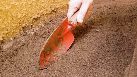 Female-hand-holds-a-metal-rake,-preparing-land-for-vegetable-garden