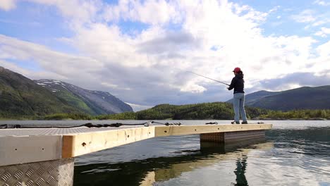woman fishing on fishing rod spinning in norway.