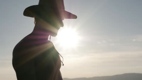 silueta de un hombre mirando a la distancia con un sombrero. luz de fondo movimiento lento