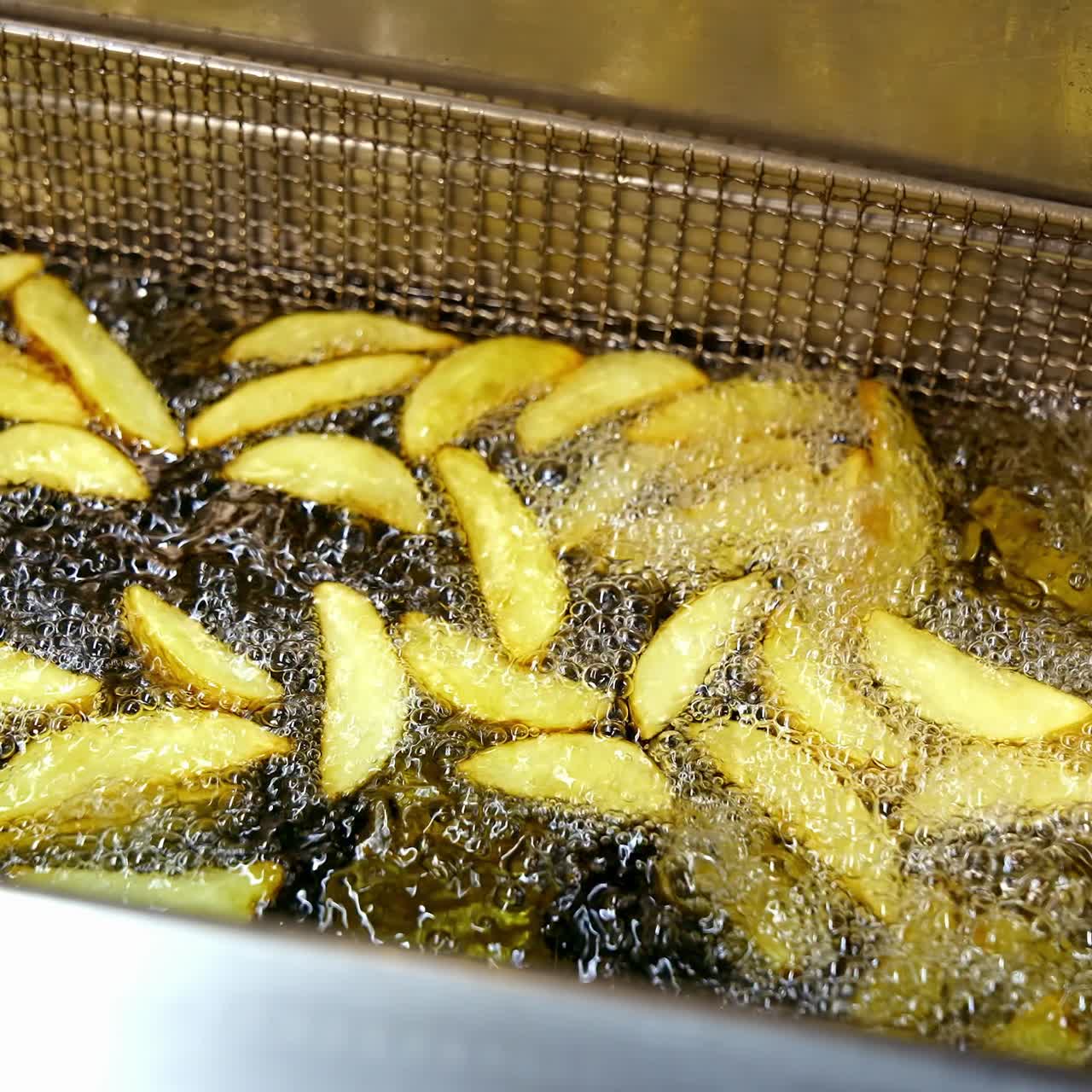 Potato in hot oil. Deep fryer cooking french fries in fast food restaurant. Tasty dish frying in boiling oil. Junk food concept