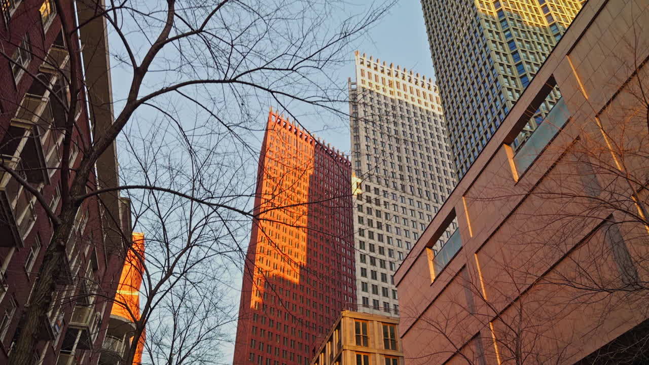 Caminhada lenta em uma cidade moderna e urbana na Europa, em Haia, na Holanda, com edifícios e arranha-céus na hora dourada, no início da noite, antes do pôr do sol, vista grande e de ângulo baixo