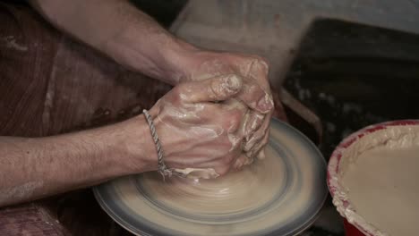 the potter makes a jug of clay. ceramist. a man makes a vase on a potter's wheel