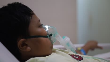 asian boy patient having viral pneumonia were treated with heat nebulizer in the hospital room