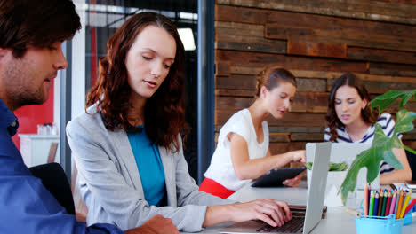 Group-of-graphic-designer-interacting-while-using-laptop