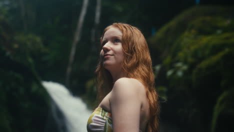 redhead woman at waterfall