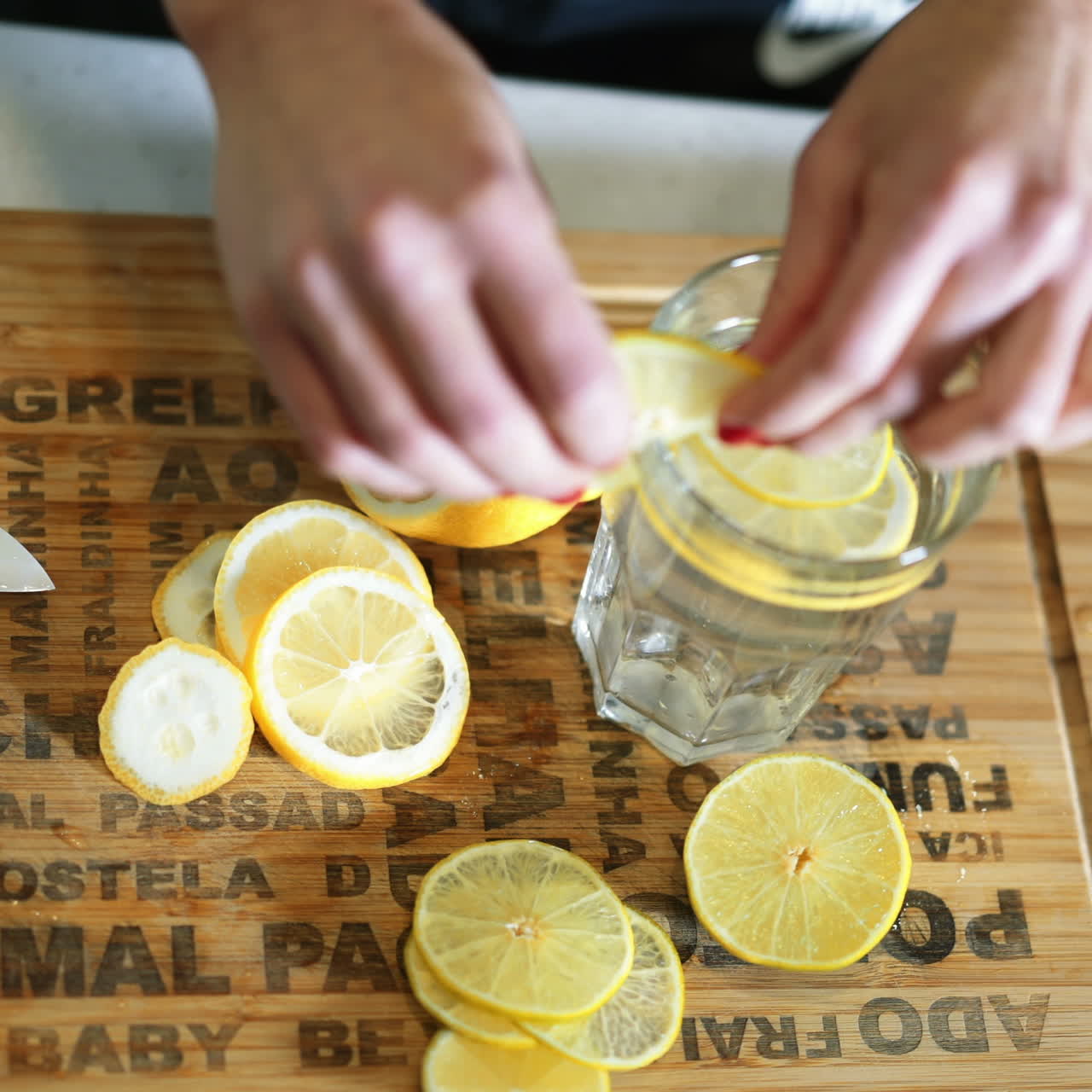 Sporty young woman prepares water with a lemon in the kitchen. Healthy lifestyle. Detox-vitaminized water. Concept of diet. Square video