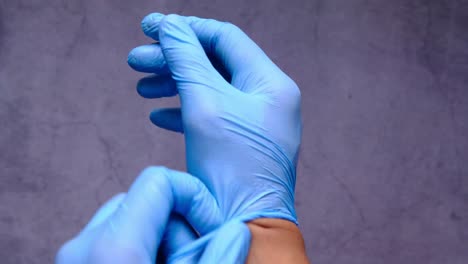 putting on blue medical gloves