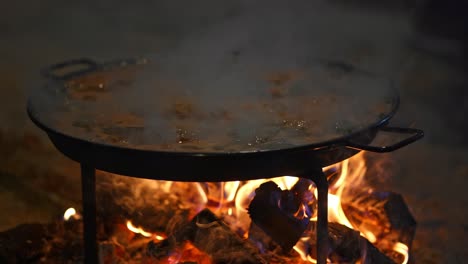 En-El-Camino,-Cierre-El-Fuego-Con-Una-Sartén-Típica-Llamada-&quot;paellero&quot;-Mientras-Cocina-La-Clásica-Paella-Valenciana,-Caldo-Hirviendo